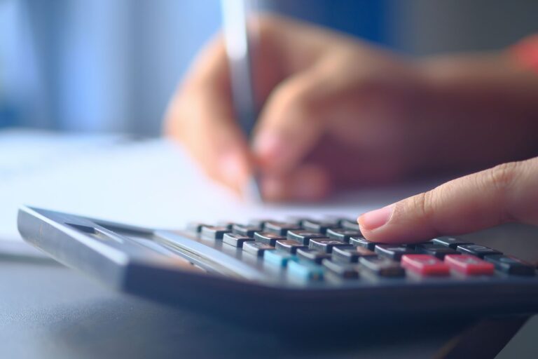 Hand pressing a calculator, illustrating a percentage increase calculator