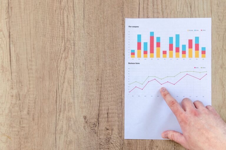Hand pointing at rate charts on paper, illustrating a home loan rate calculator